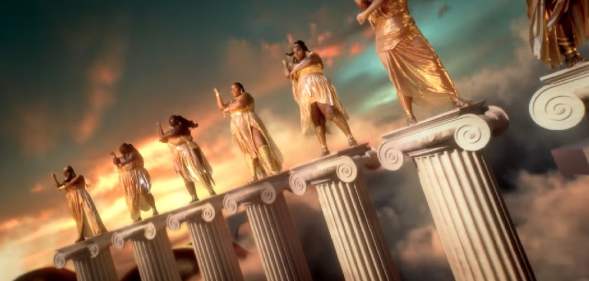 Lizzo and dancers standing atop Greek columns