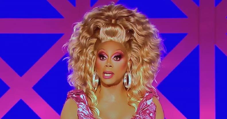 RuPaul in full drag, wearing a pink dress and blonde wig