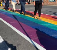 People walk across a rainbow road crossing in Port Colborne, Canada