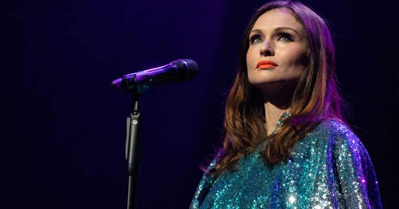 Sophie Ellis-Bextor performs in a teal dress standing behind a microphone