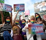Demonstrators hold up signs in support of LGBT+ legislation in the Shibuya district of Tokyo, Japan