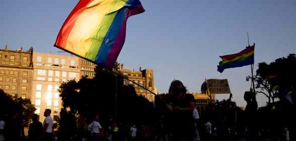 Thousands of people are demonstrating in Barcelona, Spain, waving a rainbow flag