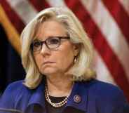 Liz Cheney in a blue jacket against the US flag