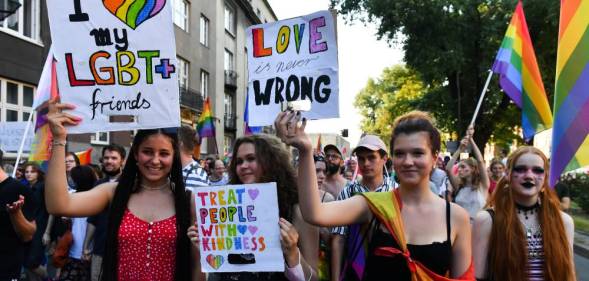 Participants holding placards supporting the LGBT+ community during Krakow Equality March in Poland