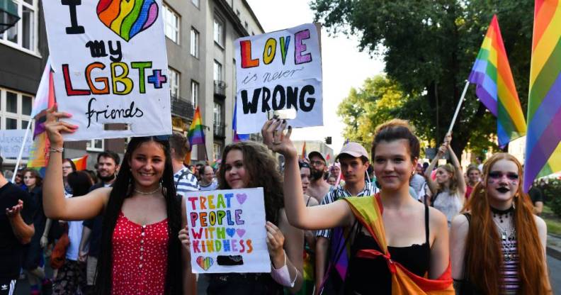 Participants holding placards supporting the LGBT+ community during Krakow Equality March in Poland