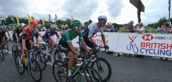 Cyclists seen in front of a sign for British Cycling, the boss of the governing body has recently condemned homophobia and transphobia in the sport