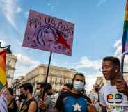 People hold placards and rainbow flags up high in Madrid