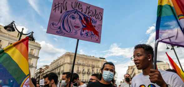 People hold placards and rainbow flags up high in Madrid
