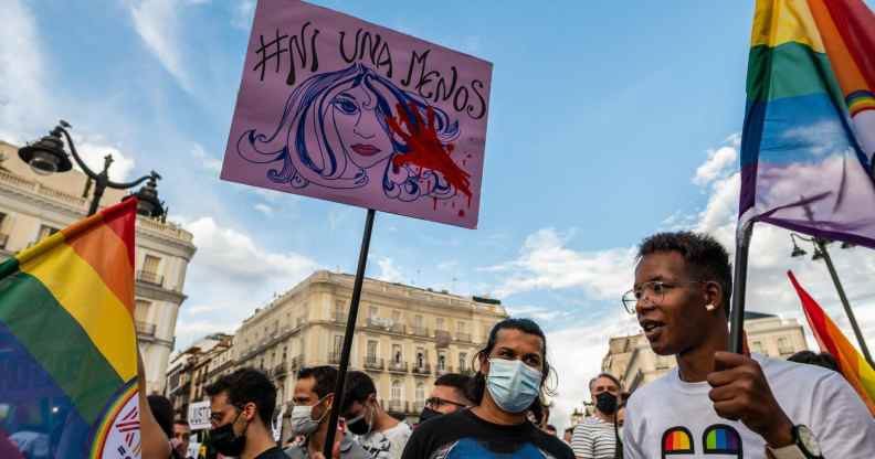 People hold placards and rainbow flags up high in Madrid