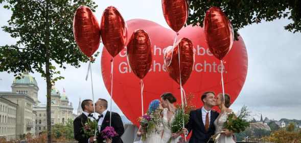 Couples pose during a photo event during a nationwide referendum's day on same-sex marriage, in Swiss capital Bern on September 26, 2021.