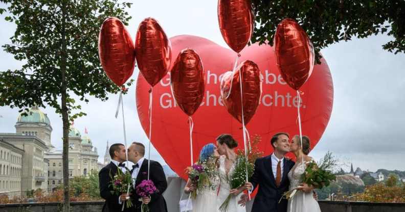 Couples pose during a photo event during a nationwide referendum's day on same-sex marriage, in Swiss capital Bern on September 26, 2021.