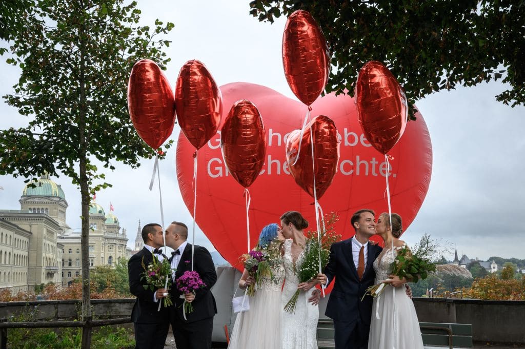 Couples pose during a photo event during a nationwide referendum's day on same-sex marriage, in Swiss capital Bern on September 26, 2021.