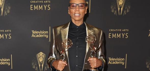 RuPaul on the red carpet at the creative arts Emmys holding his awards
