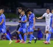 Football players leave the field as the game is suspended