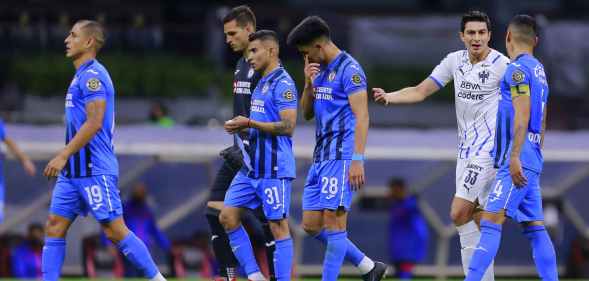 Football players leave the field as the game is suspended