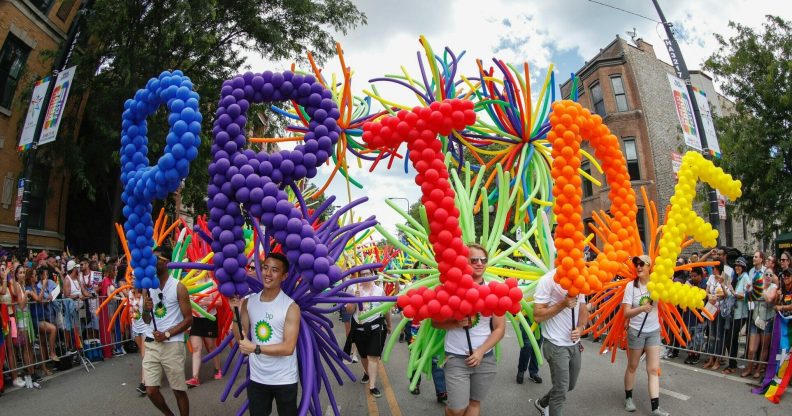 Revellers hold a Chicago Pride balloon display