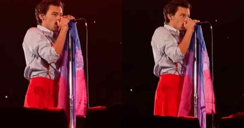 Harry Styles holds a bi Pride flag on stage