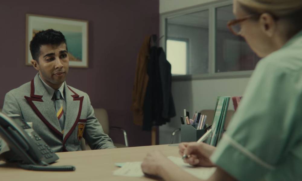 Anwar, a character from Netflix's Sex Education, sits across from a nurse at a sexual health clinic who gives him a lesson about HIV