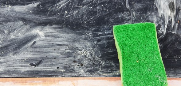 An eraser against a blackboard covered in smeared chalk