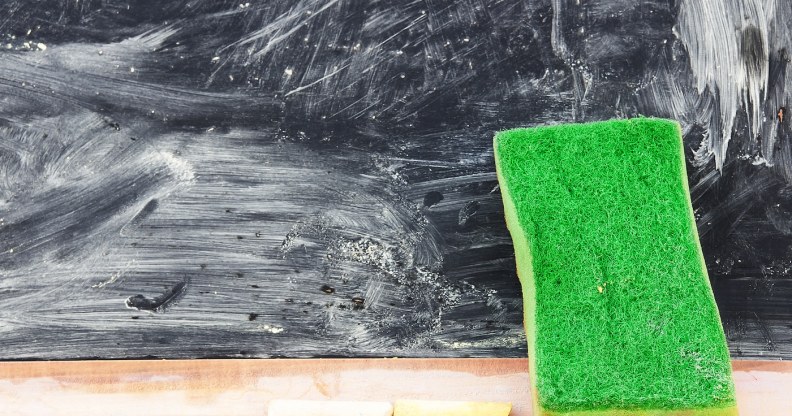 An eraser against a blackboard covered in smeared chalk