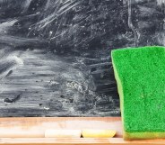 An eraser against a blackboard covered in smeared chalk
