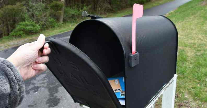 A person opening up a mailbox to illustrate trans and non-binary people from Canada seeing their deadname on voters cards in the mail