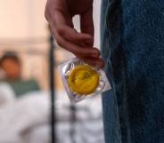 Person holds a condom behind their back while staring at their partner. This image is used to illustrate California lawmakers have sent a bill banning secretly removing a condom during sex – commongly known as 'stealthing' – to governor Gavin Newsom.