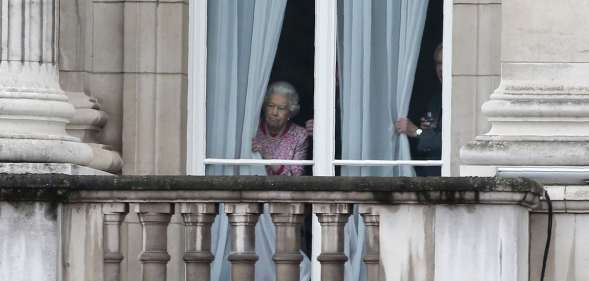 The Queen looking out of her window at Buckingham Palace.