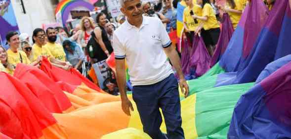 London mayor Sadiq Khan steps on top of a long LGBT+ pride flag during Pride in London 2019 celebration