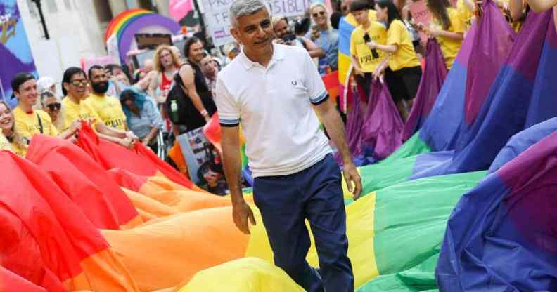 London mayor Sadiq Khan steps on top of a long LGBT+ pride flag during Pride in London 2019 celebration