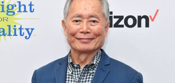 George Takei attends PFLAG conference in blue suit jacket and patterned shirt
