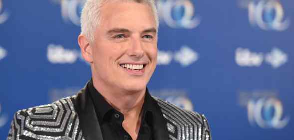 John Barrowman in a glitzy silver and black suit, smiling