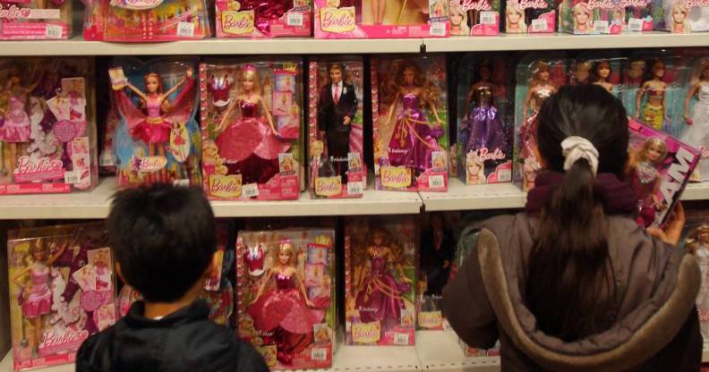 Children look at Barbie dolls in a toy store