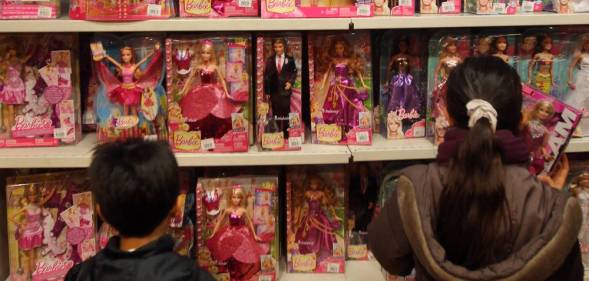 Children look at Barbie dolls in a toy store