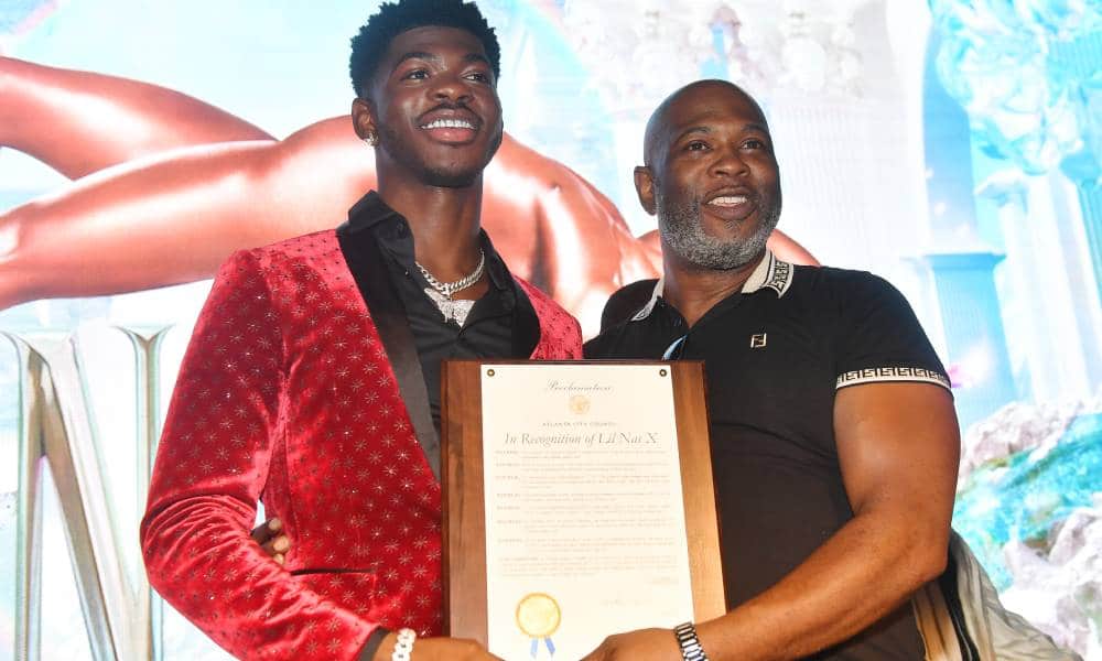 A picture of Lil Nas X and his father Robert Stafford holding up a plaque at a homecoming event for the rapper in Atlanta Georgia
