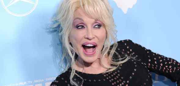 Colly Parton is dressed in black amid a light blue background at Variety and Women in Film's 2017 pre-Emmy celebration