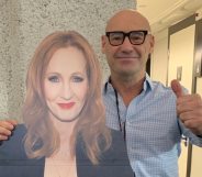 A bald man stands next to a cardboard cutout of JK Rowling