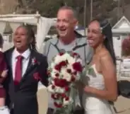 Tom Hanks posing inbetween a couple at their wedding