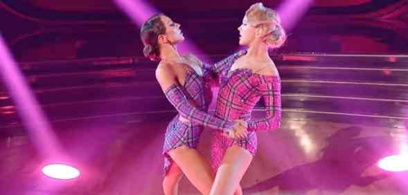 A still image of JoJo Siwa and Jenna Johnson from Dancing With the Stars where they dance amid pink and blue lighting