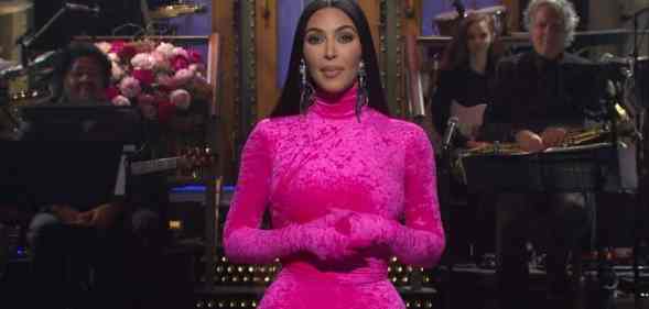 Kim Kardashian is dressed in a hot pink bodysuit onstage as host of Saturday Night Live