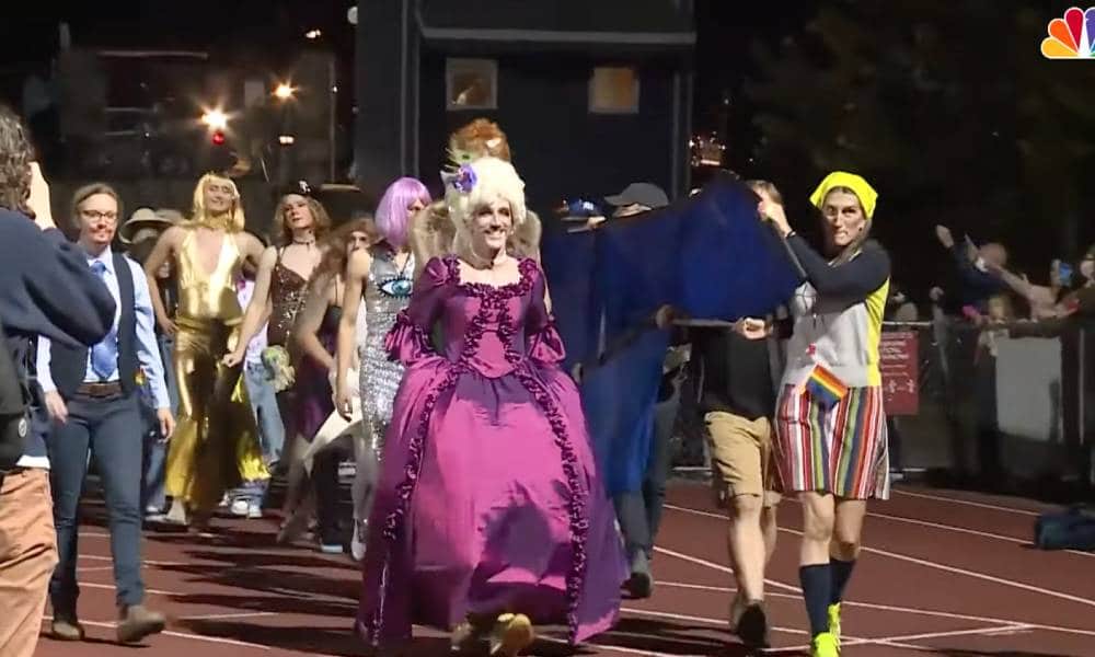 High school students and staff members in Burlington Vermont perform on the football field during a "drag ball" homecoming show