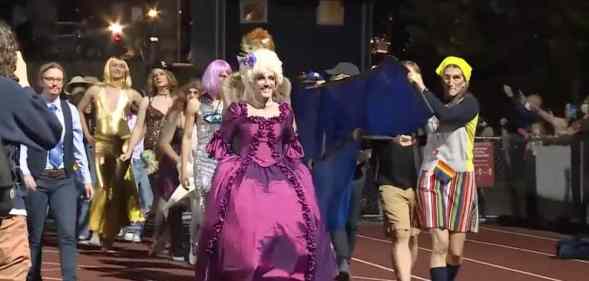 High school students and staff members in Burlington Vermont perform on the football field during a "drag ball" homecoming show