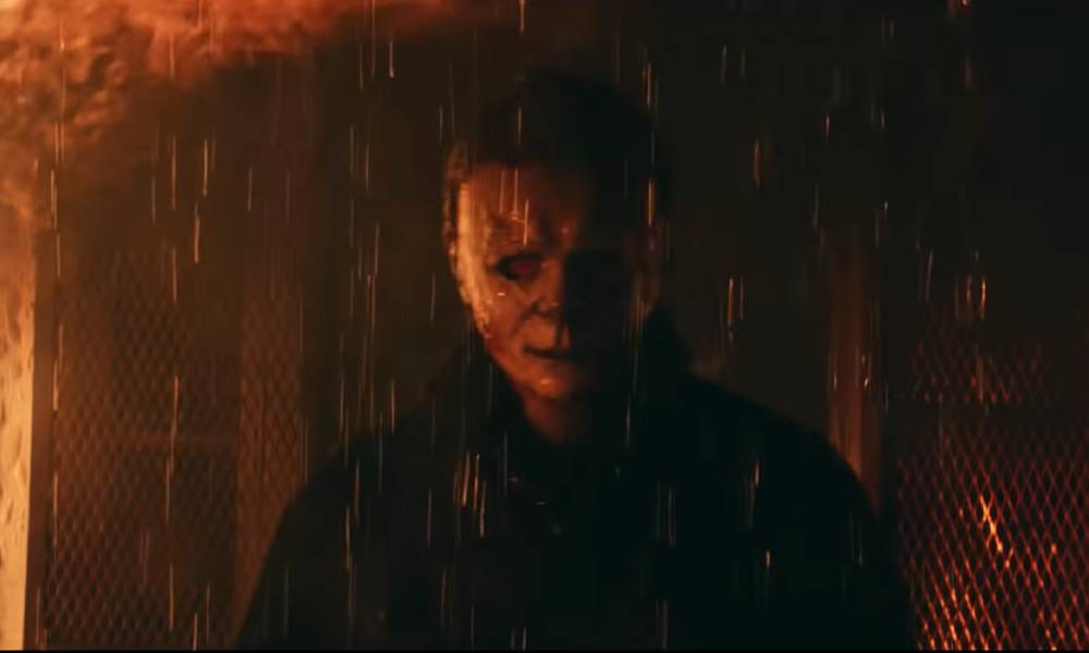 Masked killer Michael Myers steps out of a burning house in the movie Halloween Kills