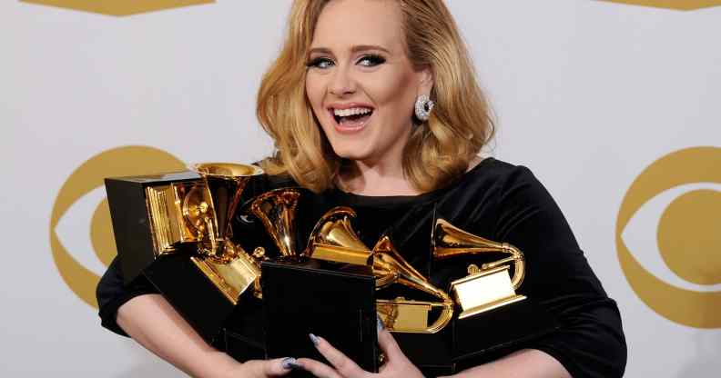 Adele holding an armful of Grammys