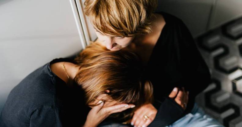 two people are holding each other as one person appears to be crying