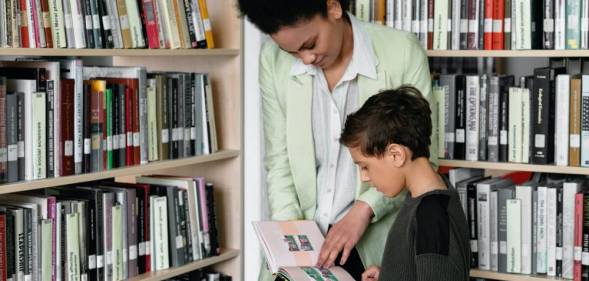 A person helps a child look at a book in a library setting