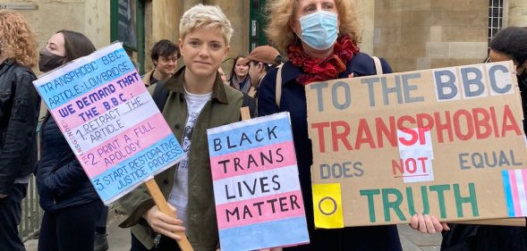 Mae Martin holds placards at the protest outside Broadcasting House