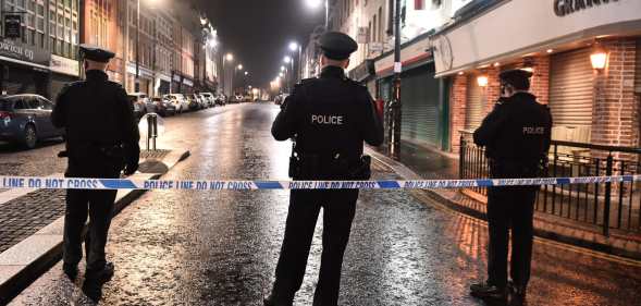 PSNI officers stand on a street at night