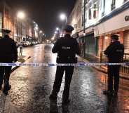 PSNI officers stand on a street at night