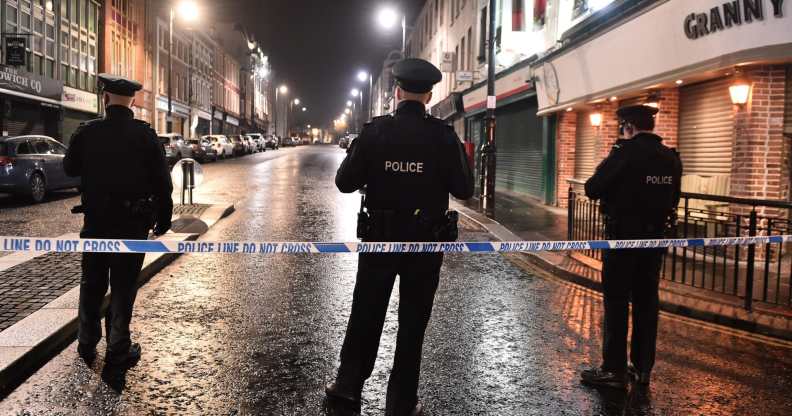 PSNI officers stand on a street at night